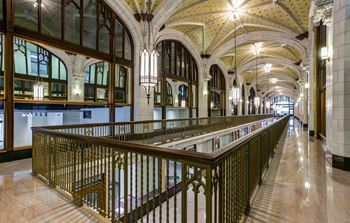 a long balcony in a building with columns and a ceiling